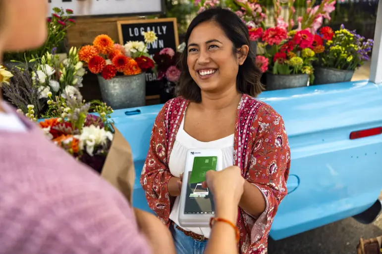 Woman using Clover Flex handheld payment 